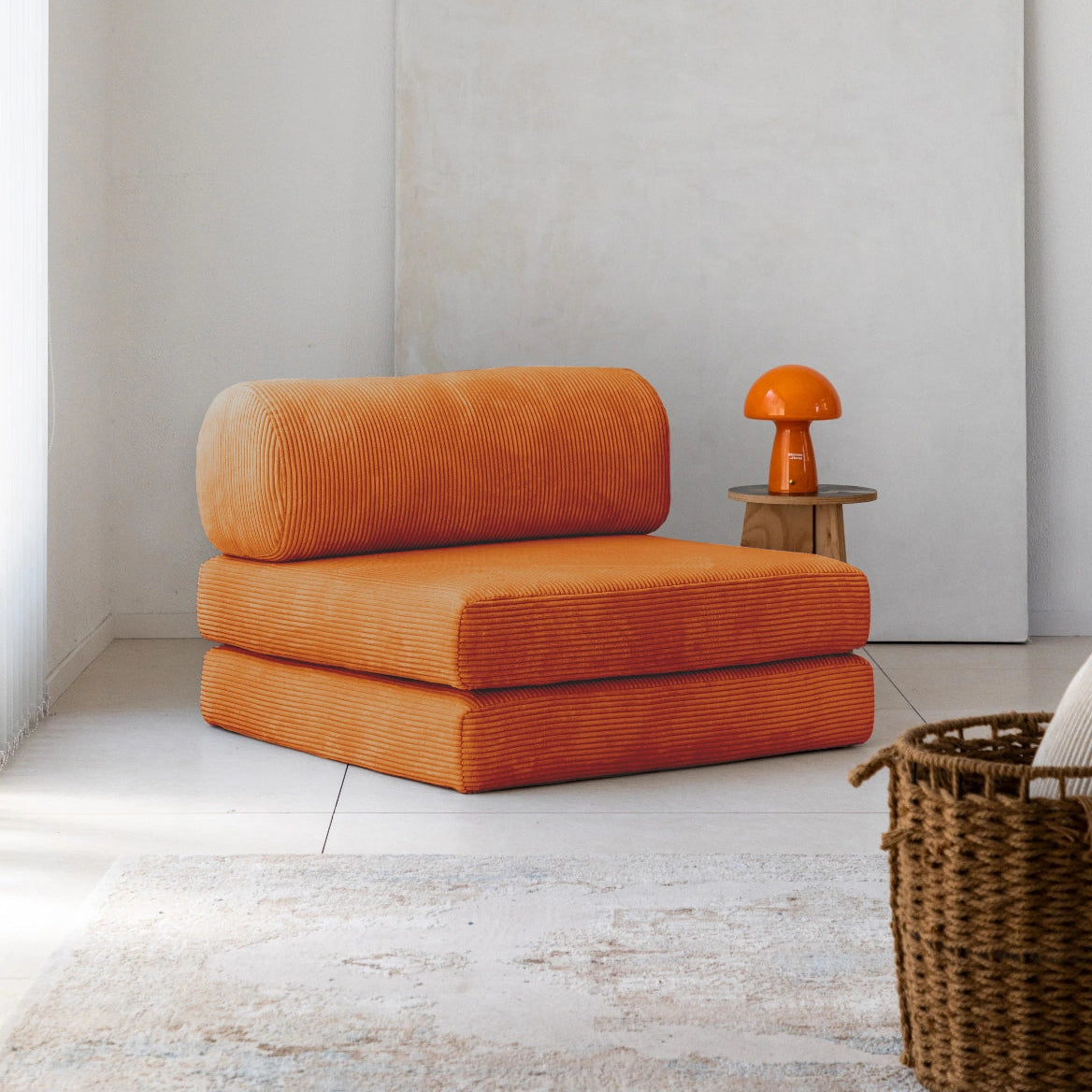 Orange modular chair in a minimalistic room with a white wall and wooden floor.